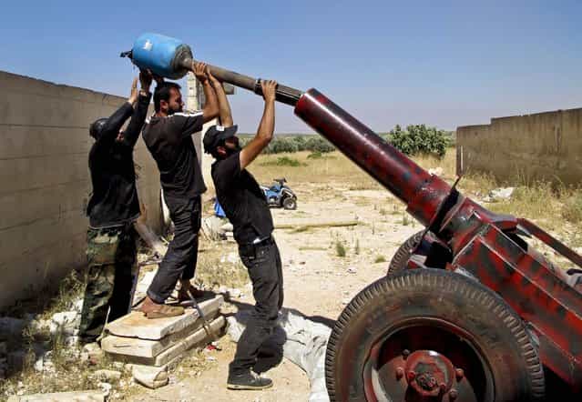 Free Syrian Army fighters prepare to fire a mortar shell during what they say is an offensive against forces loyal to Syria's President Bashar al-Assad, in Idlib, on July 17, 2013. (Photo by Abdalghne Karoof/Reuters)