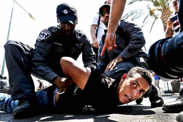 Police detain a protester during a demonstration in the southern Israeli city of Beersheba, on July 15, 2013. Protesters scuffled with Israeli police during a demonstration against an Israeli cabinet plan to relocate some 30,000 Bedouin citizens from southern Negev. According to an Israeli police spokesman, 800 protesters gathered for the demonstration of which 15 were detained. (Photo by Amir Cohen/Reuters)