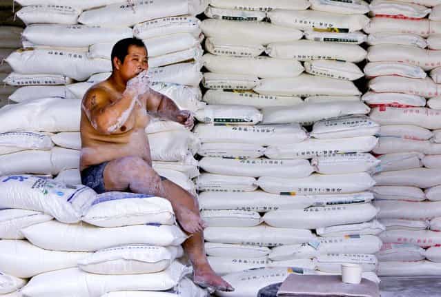 A porter smokes during a break at a flour wholesale market in Beijing, on July 18, 2013. (Photo by Jason Lee/Reuters)