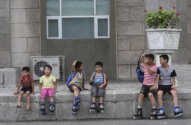 Children take a break from skating around the Kim Il Sung Square on Sunday, July 21, 2013, downtown Pyongyang, North Korea. (Photo by Wong Maye-E/AP Photo)