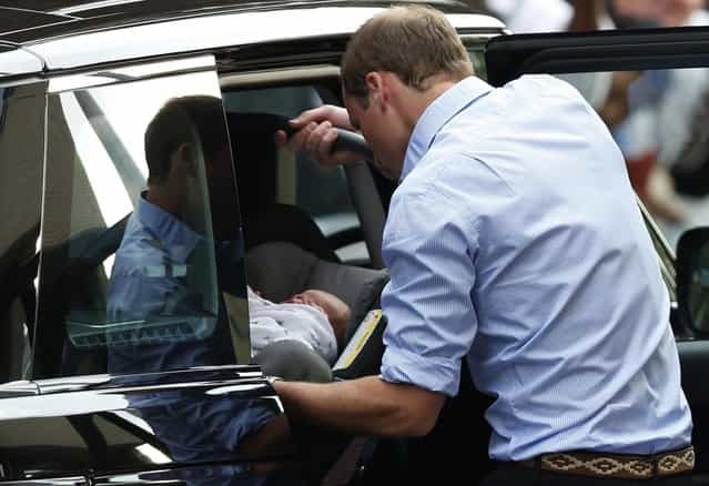 Britain's Prince William places carefully the Prince of Cambridge into a car, Tuesday July 23, 2013, as they leave St. Mary's Hospital exclusive Lindo Wing in London where the Duchess gave birth on Monday July 22. (Photo by Sang Tan/AP Photo)
