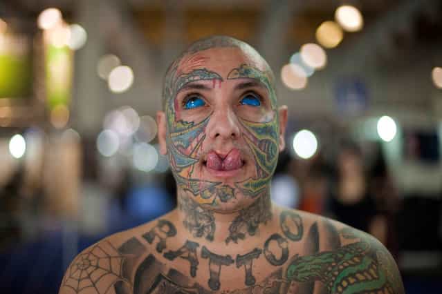 Brazilian tattoo artist who goes by the name [Rattoo], a play on the Portuguese word [rato] that means [rat], poses for pictures as he shows off his skin tattoos, his tattooed eyes and his modified split tongue during Tattoo Week events in Sao Paulo, Brazil, Friday, July 19, 2013. Tattoo Week is an annual event that attracts international tattoo artists and body piercing artists as well as consumers. (Photo by Andre Penner/AP Photo)