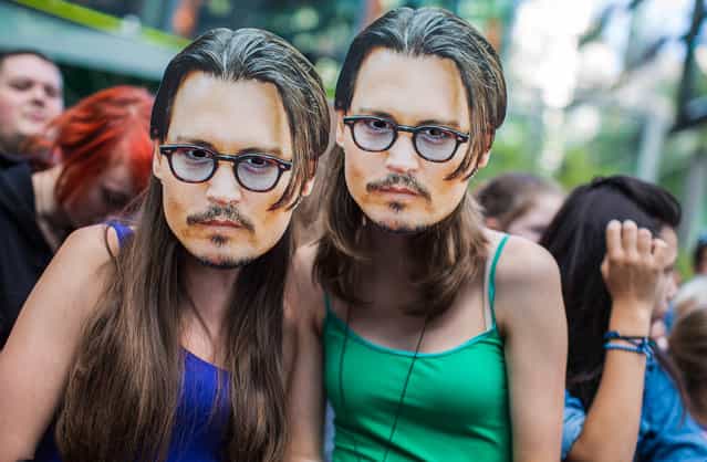 Two girls wear masks showing U.S. actor Johnny Depp as they wait for the German premiere of the movie [The Lone Ranger] in Berlin, Germany, Friday, July 19, 2013. (Photo by Gero Breloer/AP Photo)
