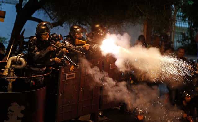 Police fire rubber bullets at demonstrators during clashes near Guanabara Palace, where Pope Francis met with President Dilma Rousseff in Rio de Janeiro, on July 22, 2013. Demonstrators are continuing their anti-government protests, which began in June amid growing economic and social dissatisfaction in Brazil. (Photo by Pilar Olivares/Reuters)