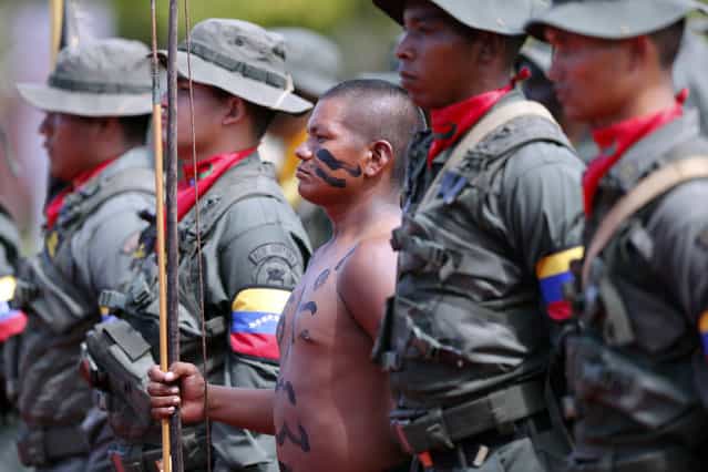 A Venezuelan indian (C) from the Amazon tribes belonging to the [Platoon of silent weapons] stands at attention with his fellow soldiers from the Venezuelan army during a welcome ceremony for Colombian President Juan Manuel Santos (not in picture) in Puerto Ayacucho July 22, 2013. (Photo by Jorge Silva/Reuters)