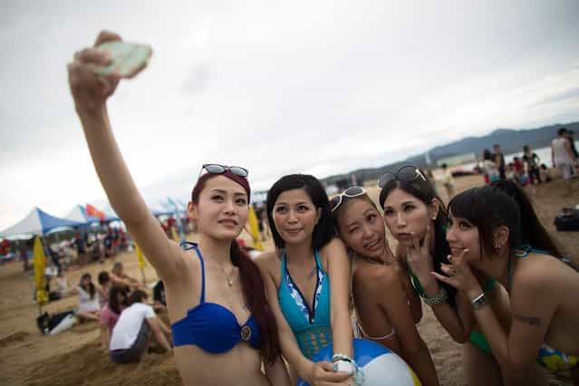 Women pose for a photo at Fulong Beach during the International Ho-Hai-Yan Gongliao Rock Festival on July 19, 2013 in Taipei, Taiwan. A once yearly celebration of Taiwanese rock and roll, the International Ho-Hai-Yan Gongliao Rock Festival is the largest and most international rock music event in Taiwan. (Photo by Lam Yik Fei/Getty Images)