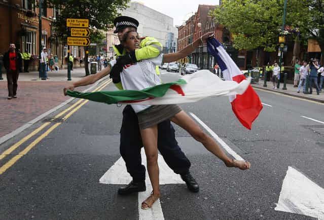 A counter-demonstrator is moved by a police officer during the EDL (right-wing and anti-Islamist English Defence League) protest in Birmingham, on July 20, 2013. (Photo by Stefan Wermuth/Reuters)