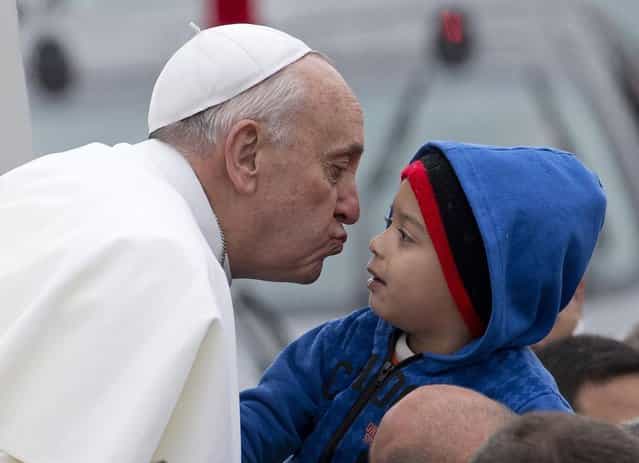 Pope Francis reaches out to kiss a child as he arrives to the Aparecida Basilicia in Aparecida, Brazil, Wednesday, July 24, 2013. (Photo by Domenico Stinellis/AP Photo)