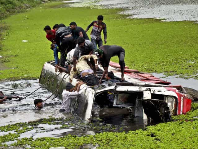 Rescuers pull out victims after a Karnataka State Road Transport Corporation bus crashed into the Vishnusamudra Lake near Belur, Karnataka state, on July 23, 2013. According to local news reports, seven bodies have been recovered so far and more are feared dead. (Photo by Associated Press)