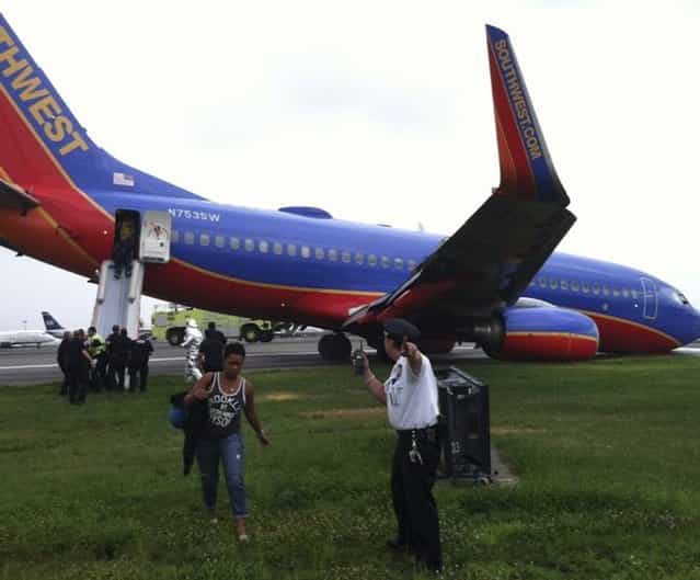 A Southwest Airlines plane sits on the tarmac as passengers disembark at LaGuardia airport in New York, July 22, 2013, in this photo courtesy of @mattjfriedman and Frank Ferramosca. The Southwest Airlines plane flying from Nashville to New York City landed without its nose gear at LaGuardia airport on Monday but no one was hurt, the Federal Aviation Administration (FAA) 

<div class=