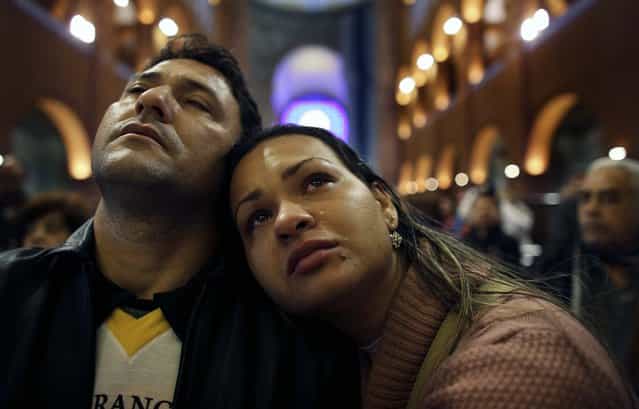 A pilgrim cries next to her husband as they pray inside the Basilica of Our Lady of Aparecida, Brazil's patron saint, in the city of Aparecida Do Norte, 103 miles east of Sao Paulo on July 23, the day before Pope Francis's visit to the basilica. (Photo by Nacho Doce/Reuters)
