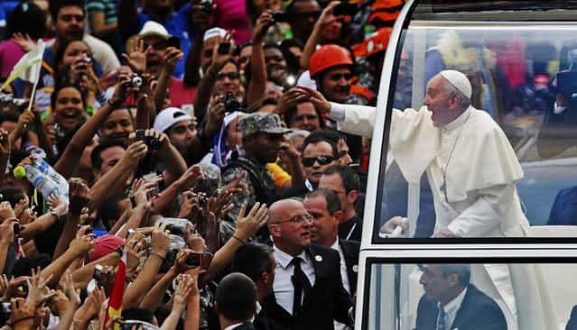 Pope Francis greets the crowd from his popemobile in downtown Rio de Janeiro. Pope Francis touched down in Rio de Janeiro on Monday, starting his first foreign trip as pontiff and a weeklong series of events expected to attract more than a million people to a gathering of young faithful in Brazil, home to the world's largest Roman Catholic population. (Photo by Ueslei Marcelino/Reuters)
