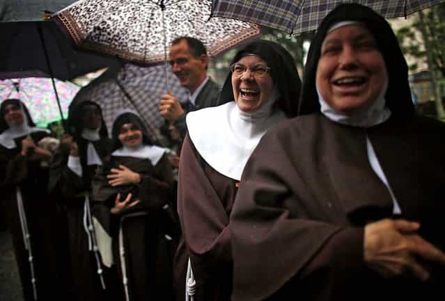 Nuns who rarely leave the Nossa Senhora dos Anjos monastery wait in line in the rain to attend Pope Francis' visit to the Hospital de Sao Francisco de Assis (Hospital of Saint Francis of Assisi) on July 24 in Rio de Janeiro. (Photo by Mario Tama/Getty Images)