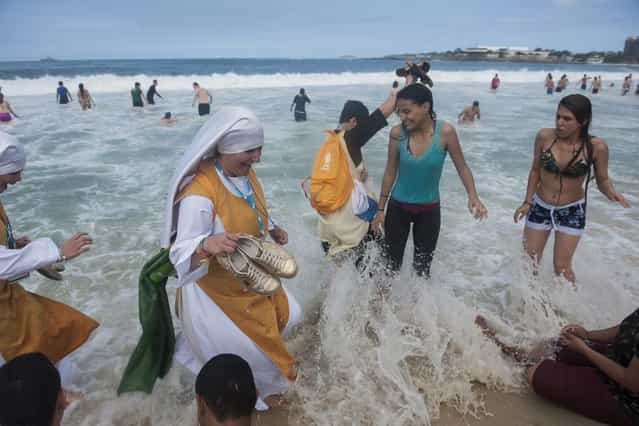Nuns wade in the Copacabana beach water, in Rio de Janeiro, Brazil, Sunday, July 28, 2013. Pope Francis wrapped up a historic trip to his home continent Sunday with the World Youth Day's closing Mass on the Copacabana beachfront. He was leaving for Rome Sunday night. (Photo by Nicolas Tanner/AP Photo)