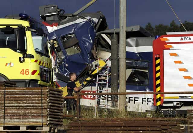 A rescue worker stands near two Swiss regional trains after a head-on collision near Granges-Pres-Marnand near Payerne in western Switzerland July 29, 2013. The two trains collided in the Swiss canton of Vaud on Monday evening, injuring about 40 people, four seriously, Swiss news agency ATS reported. There was no immediate report of any deaths in the crash. (Photo by Denis Balibouse/Reuters)