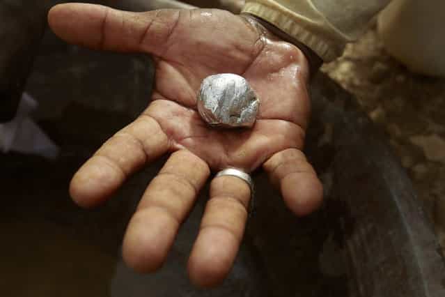 A gold mine worker displays gold in a local mine in Al-Ibedia locality at River Nile State, July 30, 2013. (Photo by Mohamed Nureldin Abdallah/Reuters)