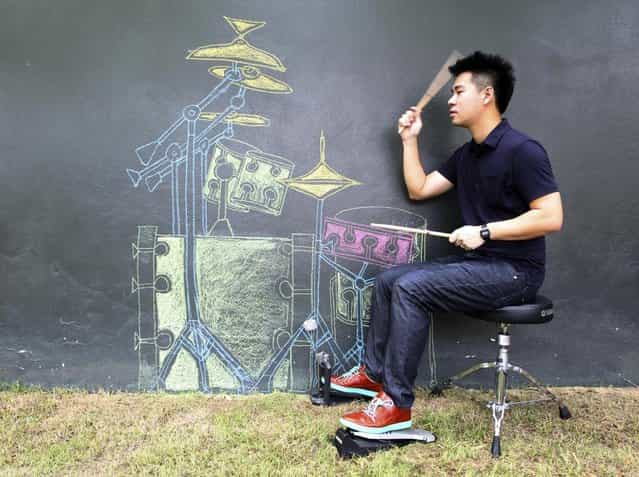 A Thai teacher Weerachat Premananda Jr., 29, plays drums he painted on the wall along with music from a music player at his home in Bangkok, Thailand Wednesday, July 31, 2013. Weerachat posted the clip of his show onlines last month and drew more than 200,000 viewers. (Photo by Apichart Weerawong/AP Photo)