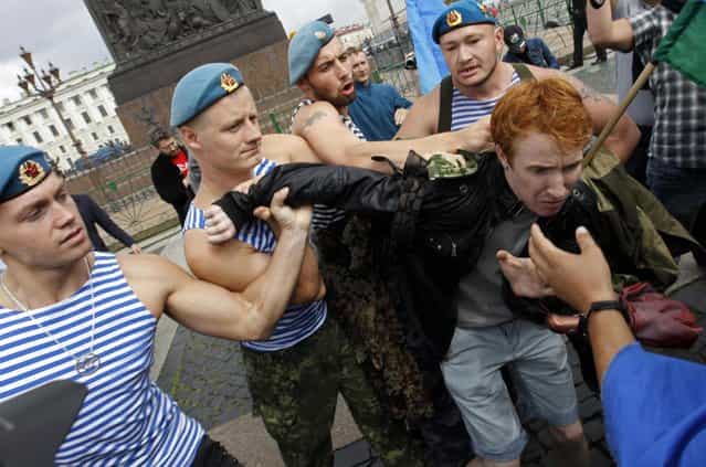 Former Russian paratroopers shove gay rights activist Kirill Kalugin aside to stop his one-man protest in St. Petersburg, August 2, 2013. The former servicemen were gathered in central St. Petersburg to celebrate Russian Paratroopers Day, an annual holiday for the Russian airborne troops celebrated since the Soviet era days. (Photo by Alexander Demianchuk/Reuters)