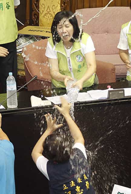 Ruling and opposition lawmakers fight with water on the legislature floor in Taipei, Taiwan, Friday, August 2, 2013. Taiwanese lawmakers exchanged punches and threw water at each other Friday ahead of an expected vote that would authorize a referendum on whether to finish a fourth nuclear power plant on this densely populated island of 23 million people. (Wally Santana/AP Photo)