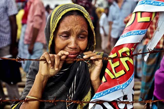 A woman cries during an event on the 100th day of the of Rana Plaza building collapse, the worst tragedy in the history of the global garment industry, near Dhaka, Bangladesh, on August 2, 2013. The collapse killed 1,129 people with many still missing. (Photo by A. M. Ahad/Associated Press)