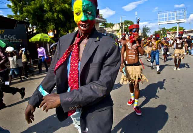 Revelers march in the [Carnival of Flowers] parade in Port-au-Prince, Haiti, on July 29, 2013. Tens of thousands of people poured into downtown Port-au-Prince for the Caribbean nation's second [Carnival of Flowers], a three-day celebration President Michel Martelly has revived from the Duvalier era. (Photo by Dieu Nalio Chery/Associated Press)