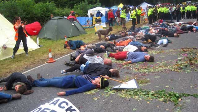 Anti-fracking activists pretending to drop down dead in the middle of the road after a lorry had delivered equipment to a proposed oil exploration drilling site outside Balcombe, West Sussex, on July 31, 2013. (Photo by Tom Pugh/PA Wire)