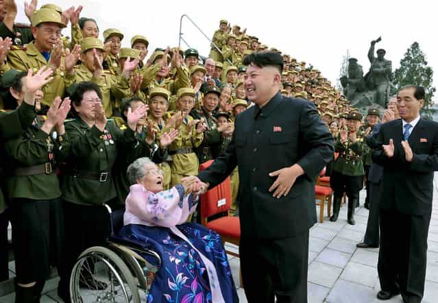 North Korean leader Kim Jong-Un laughs during a photo session with war veteran delegates who took part in the celebrations of the 60th anniversary of the signing of the truce of the Korean War, in this undated photo released by North Korea's Korean Central News Agency. (Photo by Reuters/KCNA)