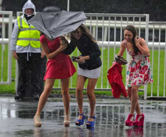 Sinead Flynn, Aine Murray, Catherine Fearty battle against the weather during day four of the 2013 Galway Summer Festival at Galway Racecourse, Ballybrit, Ireland, on August 1, 2013. (Photo by Barry Cronin/PA Wire)