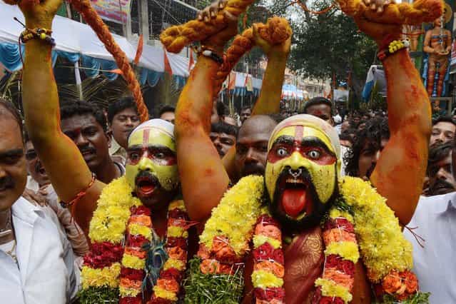 Indian Hindu devotees representing Potharaju, brother of the goddess Mahankali, dance in the streets during the Bonalu festival at the Sri Ujjaini Mahakali Temple in Secunderabad, India, on July 30, 2013. (Photo by Noah Seelam/AFP Photo)