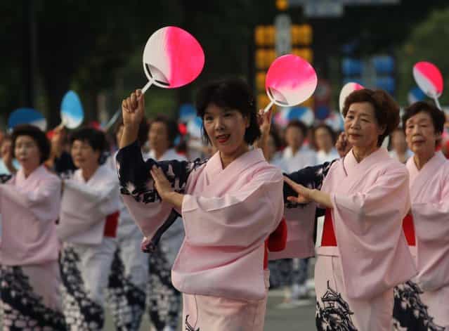 Women dress traditional in costume perform folk dance during the annual Himeji Castle Festival on August 3, 2013 in Himeji, Japan. The parade of Castle Queens is part of the traditional matsuri festival around the UNESCO world heritage Himeji Castle. (Photo by Buddhika Weerasinghe/Getty Images)