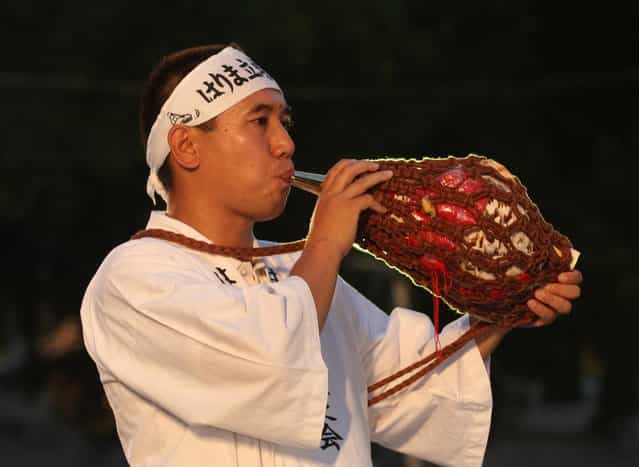 A man performs horagi, conch shell trumpet during the annual Himeji Castle Festival on August 3, 2013 in Himeji, Japan. The parade of Castle Queens is part of the traditional matsuri festival around the UNESCO world heritage Himeji Castle. (Photo by Buddhika Weerasinghe/Getty Images)