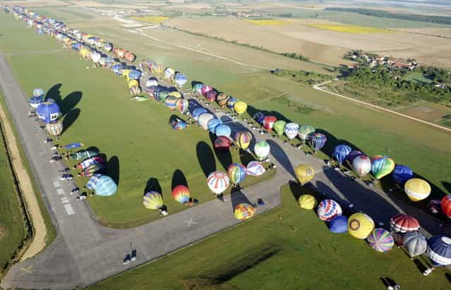 Over 390 hot air-balloons prepare to take off in Chambley-Bussieres, eastern France on Aug. 1, 2013 to set a world record of collective taking-off during the yearly event [Lorraine Mondial air ballons], an international air-balloon meeting. (Photo by Jean Christophe Verhaegen/AP Photo)