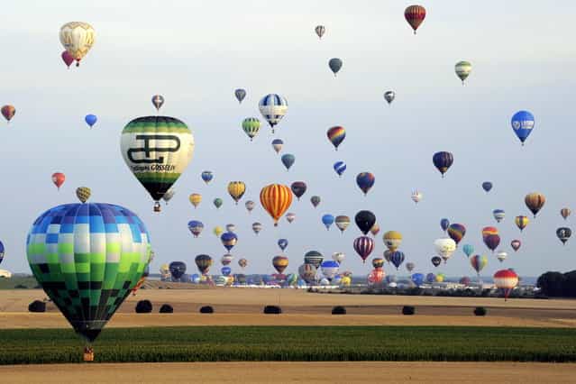 Hot-air balloons take off in Chambley-Bussieres, eastern France, on Saturday July 27, 2013 in an attempt to set a world record for collective taking-off during the event [Lorraine Mondial air ballons], an international hot-air balloon meeting. (Photo by Alexandre Marchi/AP Photo/L'est Republicain)