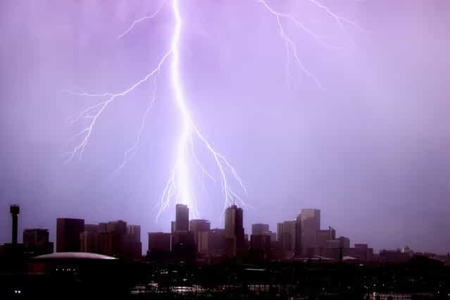 A huge blast of purple-tinged lightning strikes a skyscraper in Denver, Colorado. (Photo by Greg Thow/Barcroft Media)