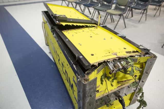 The damaged box after escape artist Anthony Martin escaped from it after being dropped from an airplane in Ottawa, Ill., Tuesday, Aug. 6, 2013. Martin, of Sheboygan, Wis., is no stranger to extracting himself from tricky situations. Since his first escape from handcuffs at the age of 10, he has wriggled his way out of straitjackets, ropes, chains, jail cells, coffins and a cage submerged under water. (Photo by Scott Eisen/AP Photo)