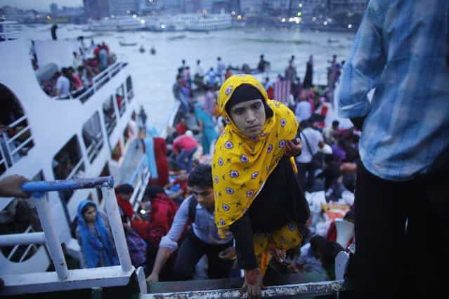A woman boards on an overcrowded passenger boat at Sadarghat boat terminal in Dhaka August 7, 2013. Millions of residents in Dhaka have started the exodus home from the capital city ahead of the Eid al-Fitr holiday, which marks the end of the fasting month of Ramadan. (Photo by Andrew Biraj/Reuters)