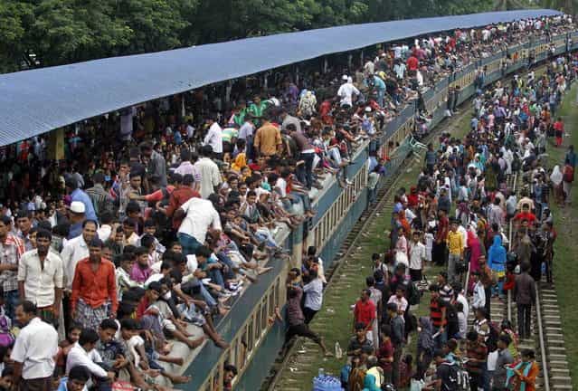 Passengers climb to board an overcrowded train at a railway station in Dhaka August 8, 2013. Millions of residents in Dhaka are travelling home from the capital city to celebrate the Muslim Eid al-Fitr holiday, which marks the end of the Muslim holy fasting month of Ramadan. (Photo by Andrew Biraj/Reuters)