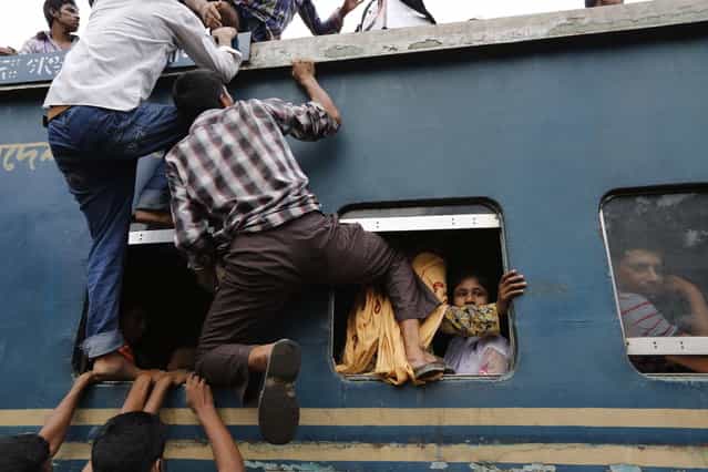 Passengers try to climb to the top of an overcrowded train at a railway station in Dhaka August 8, 2013. Millions of residents in Dhaka are travelling home from the capital city to celebrate the Muslim Eid al-Fitr holiday, which marks the end of the holy fasting month of Ramadan. (Photo by Andrew Biraj/Reuters)