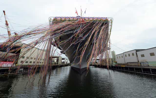 Japan's newest warship, the DDH183 Izumo, is pictured during a launch ceremony in Yokohama on August 6, 2013. The 248-metre-long and 19,500-tonne helicopter destroyer is the biggest warship since World War II in a move likely to jangle nerves among neighbours China and South Korea, as Tokyo mulls an overhaul of its pacifist constitution. (Photo by Toshifumi Kitamura/AFP Photo)