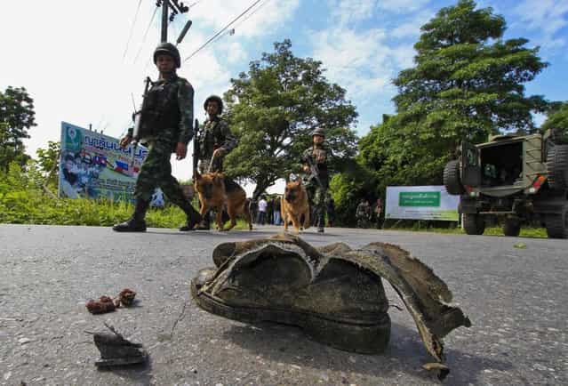 Thai security personnel inspect the site of a bomb attack on a roadside in Yala province, south of Bangkok, August 5, 2013. Five field army soldiers were injured after the explosion by suspected Muslim militants, as they were making their way to provide escort to teachers travelling to school, police said. (Photo by Surapan Boonthanom/Reuters)