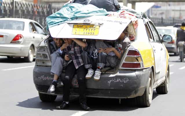 Boys sit in the boot of a car in Sanaa August 8, 2013. (Photo by Mohamed al-Sayaghi/Reuters)