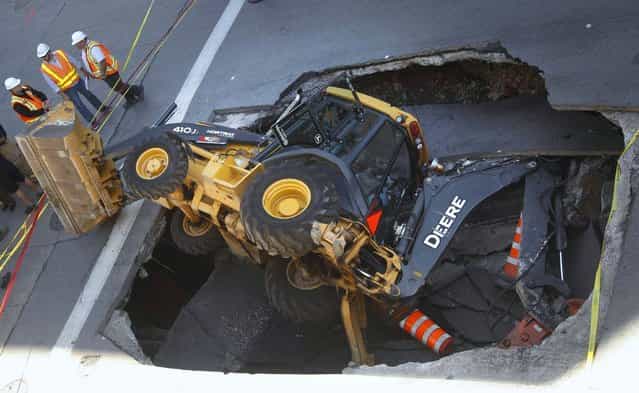 A construction vehicle lies where it was swallowed by a sinkhole on Saint-Catherine Street in downtown Montreal, August 5, 2013. (Photo by Christinne Muschi/Reuters)