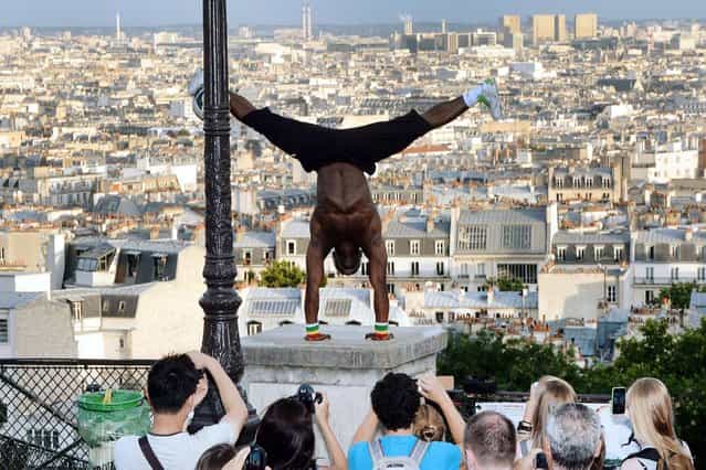 Guinea born Iya Traore, a former football player, juggler and acrobate performs in Paris, on August 6, 2013. (Photo by Pierre Andrieu/AFP Photo)