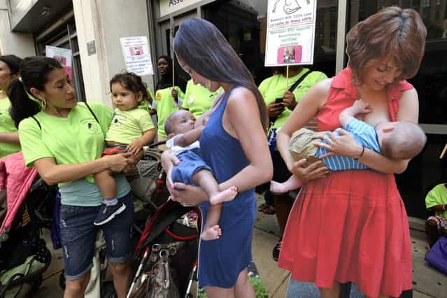 Women stand next to cardboard posters in the Washington Heights section of New Yorkas they participate in the annual [Breastfeeding Subway Caravan] to mark [World Breastfeeding Week], on August 3, 2013. (Photo by AFP Photos/Getty Images)