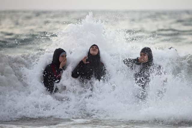 Palestinian women enjoy the Mediterranean sea during the Eid al-Fitr holiday, in Tel Aviv, Israel, Saturday, August 10, 2013. The three-day Eid al-Fitr holiday marks the end of the holy fasting month of Ramadan. One of the most important holidays in the Muslim world, Eid al-Fitr, is marked with prayers, family reunions and other festivities. (Photo by Oded Balilty/AP Photo)
