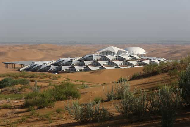Desert Lotus Hotel under construction is seen in Xiangshawan Desert, also called Sounding Sand Desert on July 19, 2013 in Ordos of Inner Mongolia Autonomous Region, China. Xiangshawan is China's famous tourist resort in the desert. It is located along the middle section of Kubuqi Desert on the south tip of Dalate League under Ordos City. Sliding down from the 110-metre-high, 45-degree sand hill, running a course of 200 metres, the sands produce the sound of automobile engines, a natural phenomenon that nobody can explain. (Photo by Feng Li/Getty Images)