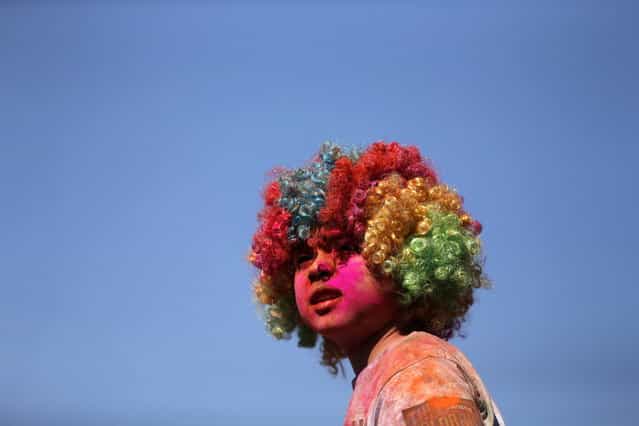 A child wearing a wig looks at the stage after finishing the Colour Run at Centennial Park in Sydney August 25, 2013. According to organizers, 15,000 runners registered to complete the 5km (3 miles) course in Centennial Park on Sunday, being covered in blue, pink, orange and yellow powder on their way to finish line. (Photo by Daniel Munoz/Reuters)