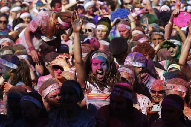 A woman dances after finishing the Colour Run at Centennial Park in Sydney August 25, 2013. According to organizers, 15,000 runners registered to complete the 5km (3 miles) course in Centennial Park on Sunday, being covered in blue, pink, orange and yellow powder on their way to the finish line. (Photo by Daniel Munoz/Reuters)