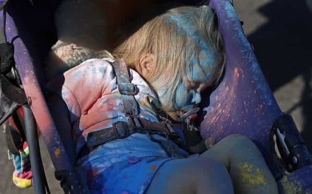 A girl covered in blue powder sleeps during the Colour Run at Centennial Park in Sydney August 25, 2013. According to organizers, 15,000 runners registered to complete the 5km (3 miles) course in Centennial Park on Sunday, being covered in blue, pink, orange and yellow powder on their way to the finish line. (Photo by Daniel Munoz/Reuters)