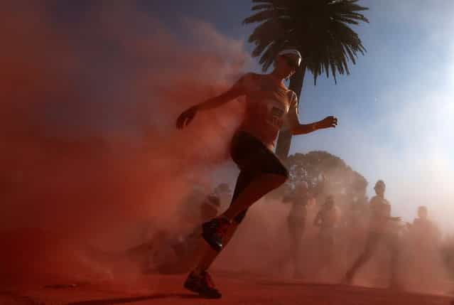A woman leaves the pink zone at the Colour Run at Centennial Park in Sydney August 25, 2013. According to organizers, 15,000 runners registered to complete the 5km (3 miles) course in Centennial Park this Sunday, being covered in blue, pink, orange and yellow powder on their way to the finish line. (Photo by Daniel Munoz/Reuters)